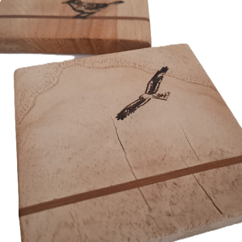 Colección Origen: el núcleo de Siete Maderas. Un posavasos Luz de madera con grabado de águila que simboliza la conexión con lo orgánico y atemporal.