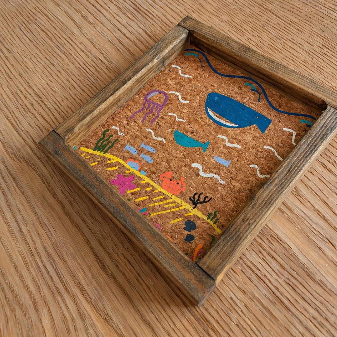 Bandeja vaciabolsillos hecha a mano por Siete Maderas en Málaga. De madera con ilustraciones pintadas a mano marinas de ballenas y medusas sobre corcho natural.