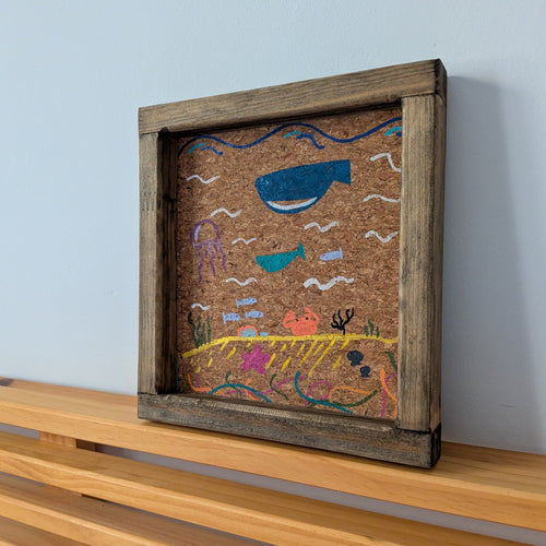 Bandeja vaciabolsillos hecha a mano por Siete Maderas en Málaga. De madera con ilustraciones pintadas a mano marinas de ballenas y medusas sobre corcho natural.