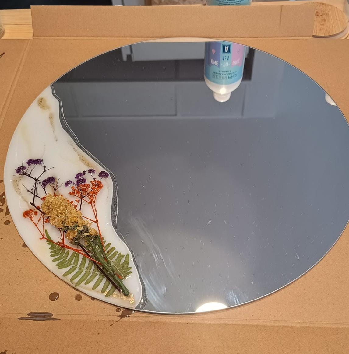 Espejo intervenido con resina y flores secas y preservadas por Siete Maderas. Diseño único con base blanca y dorada. Flores silvestres.