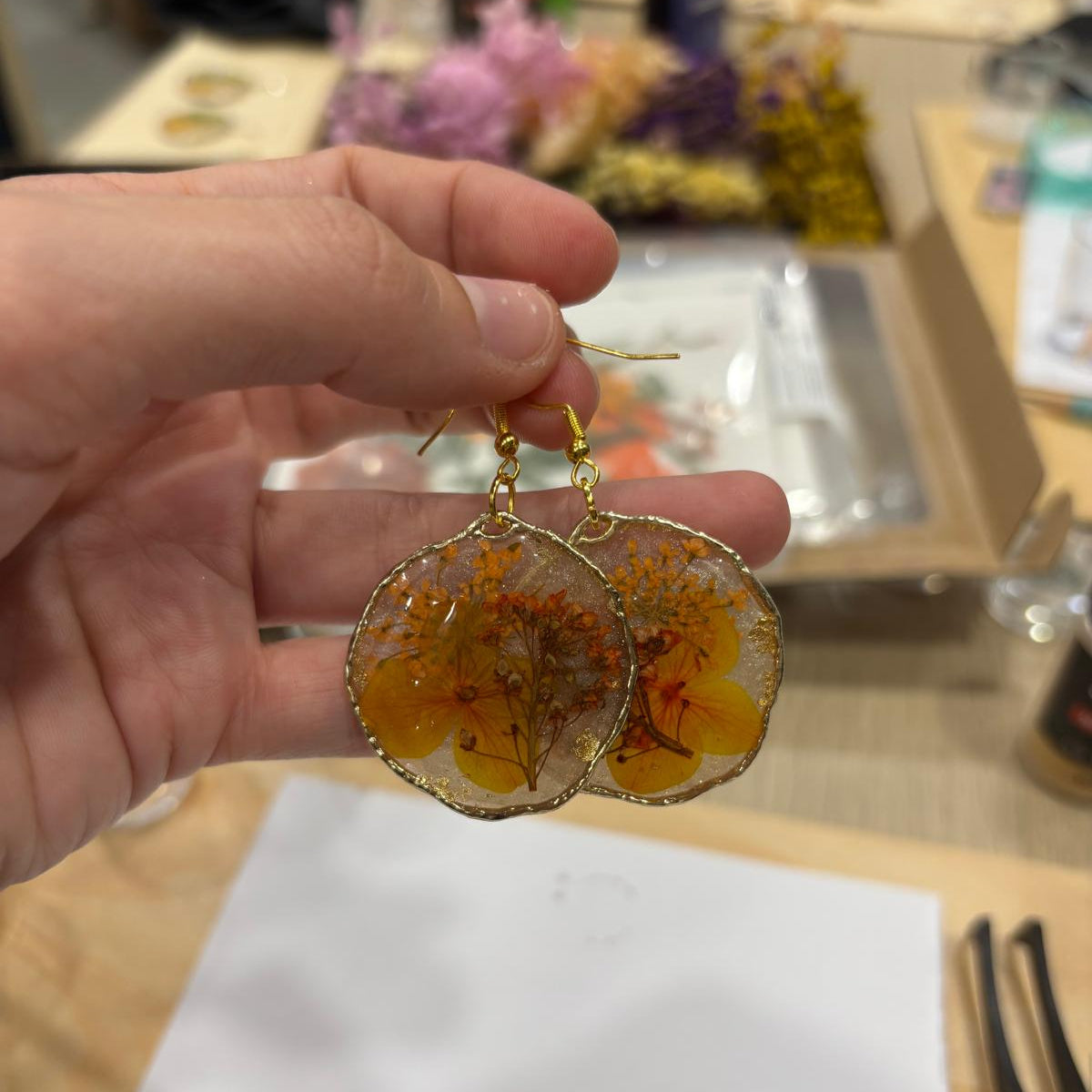 Pendientes de Siete Maderas con flores y resina. Pieza de alumna.