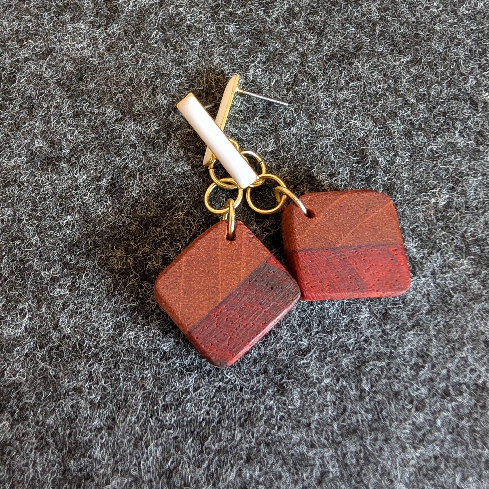 Pendientes de madera hechos a mano por Siete Maderas. Forma cuadrada y colgante dorado y blanco.