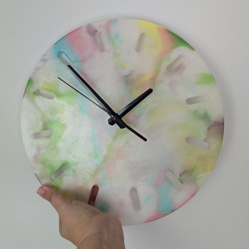 Reloj de resina hecho a mano por Siete Maderas. Fondo blanco nácar y multicolor. Diseño único.