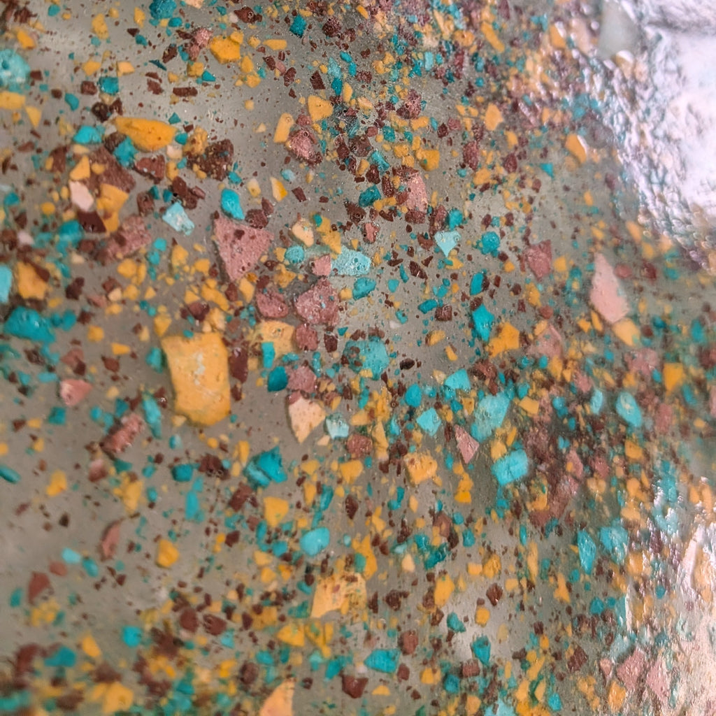 Detalle del reloj grava hecho con resina ecológica simulando grava de colores en resina epoxy. Colores verde, mostaza y marrón.