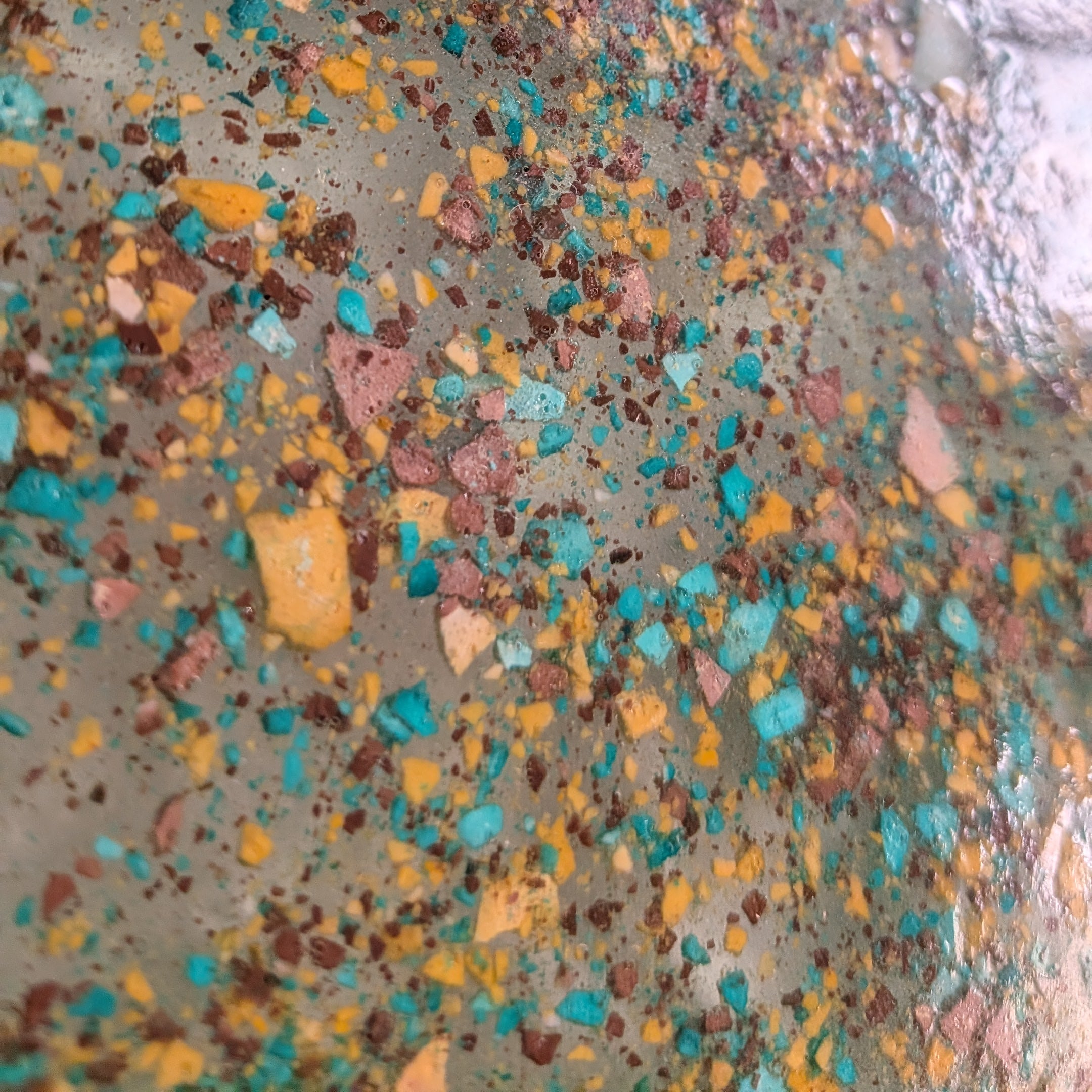 Detalle del reloj grava hecho con resina ecológica simulando grava de colores en resina epoxy. Colores verde, mostaza y marrón.