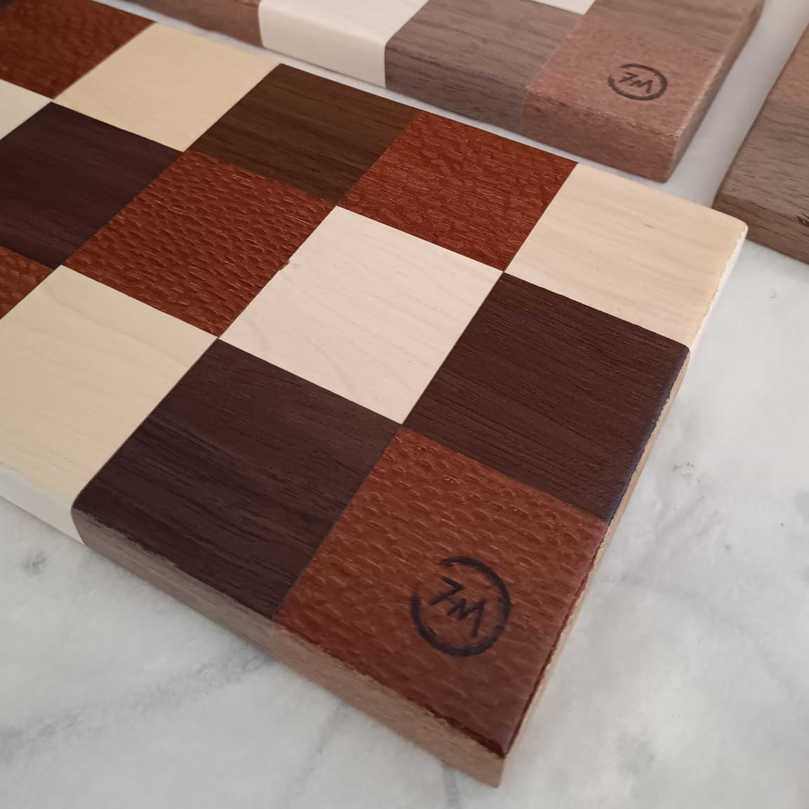 Tabla de servir hecha a mano por Siete Maderas con maderas nobles y patrón de mosaico.