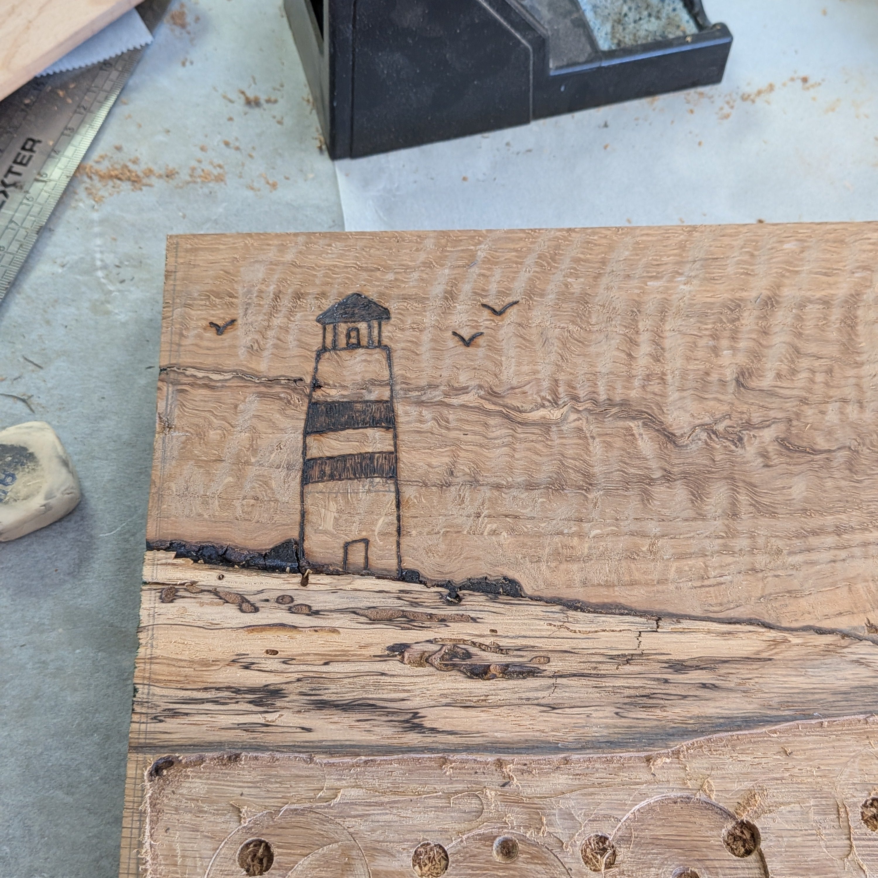 Tabla de servir El faro, hecha a mano por Siete Maderas en madera de roble, usando el nudo como parte del diseño y con detalles en resina simulando el mar y pirograbado dibujando un faro y unas gaviotas. Proceso creativo.