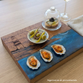 Tabla de servir El faro, hecha a mano por Siete Maderas en madera de roble, usando el nudo como parte del diseño y con detalles en resina simulando el mar y pirograbado dibujando un faro y unas gaviotas. Sugerencia de presentación