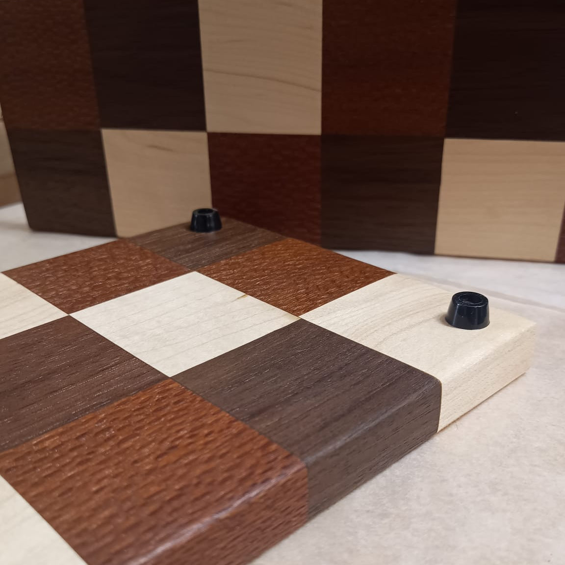 Tablas de servir hechas con patrón de mosaico con distintas maderas por Siete Maderas. Detalle de las patas de goma.