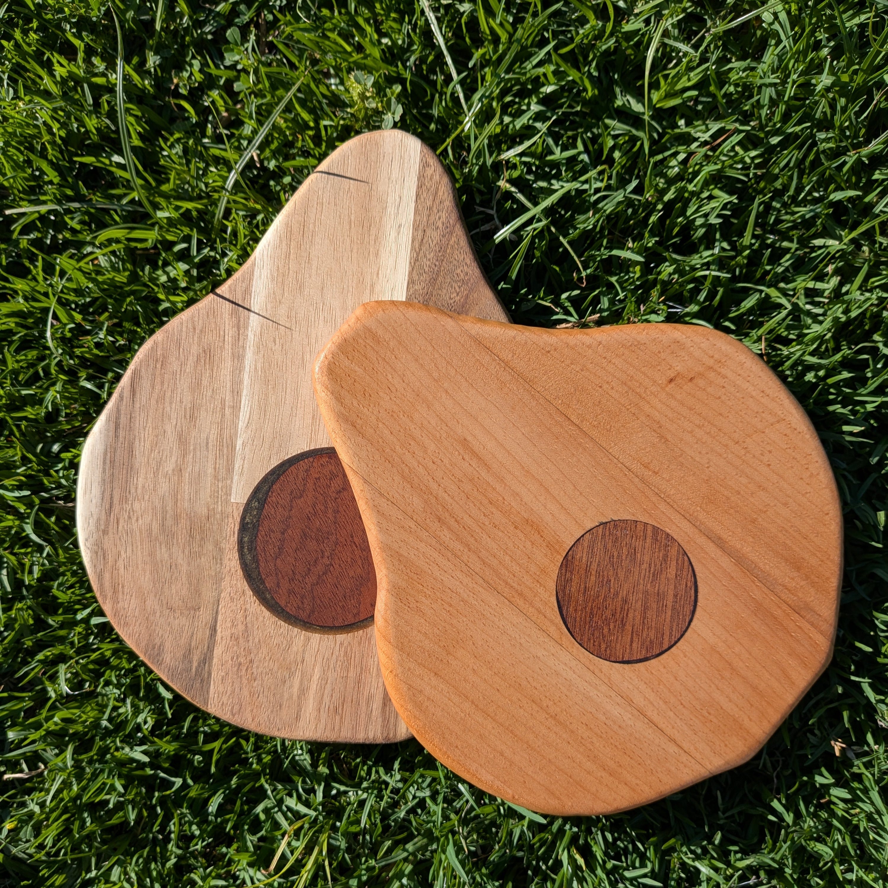Ejemplos de dos tablas de servir con forma de aguacate hechas por Siete Maderas a mano usando maderas nobles.