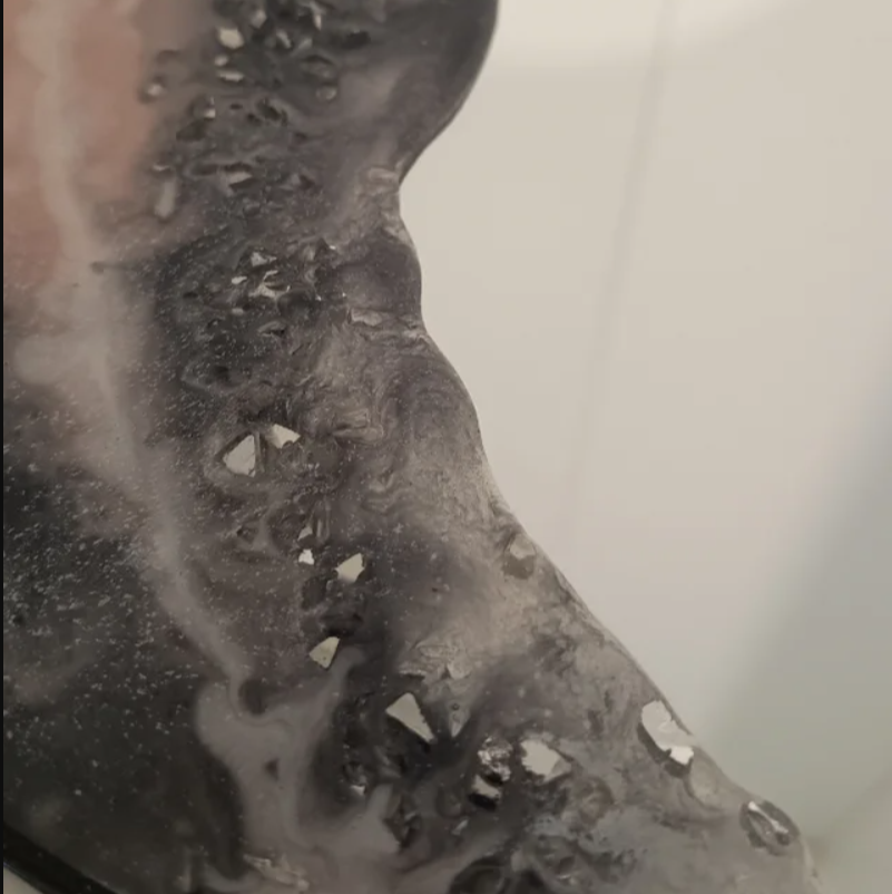 Primer plano del Espejo Obsidiana. Resina con inclusiones de espejos/cristales que crean un efecto único. Cada detalle es arte.