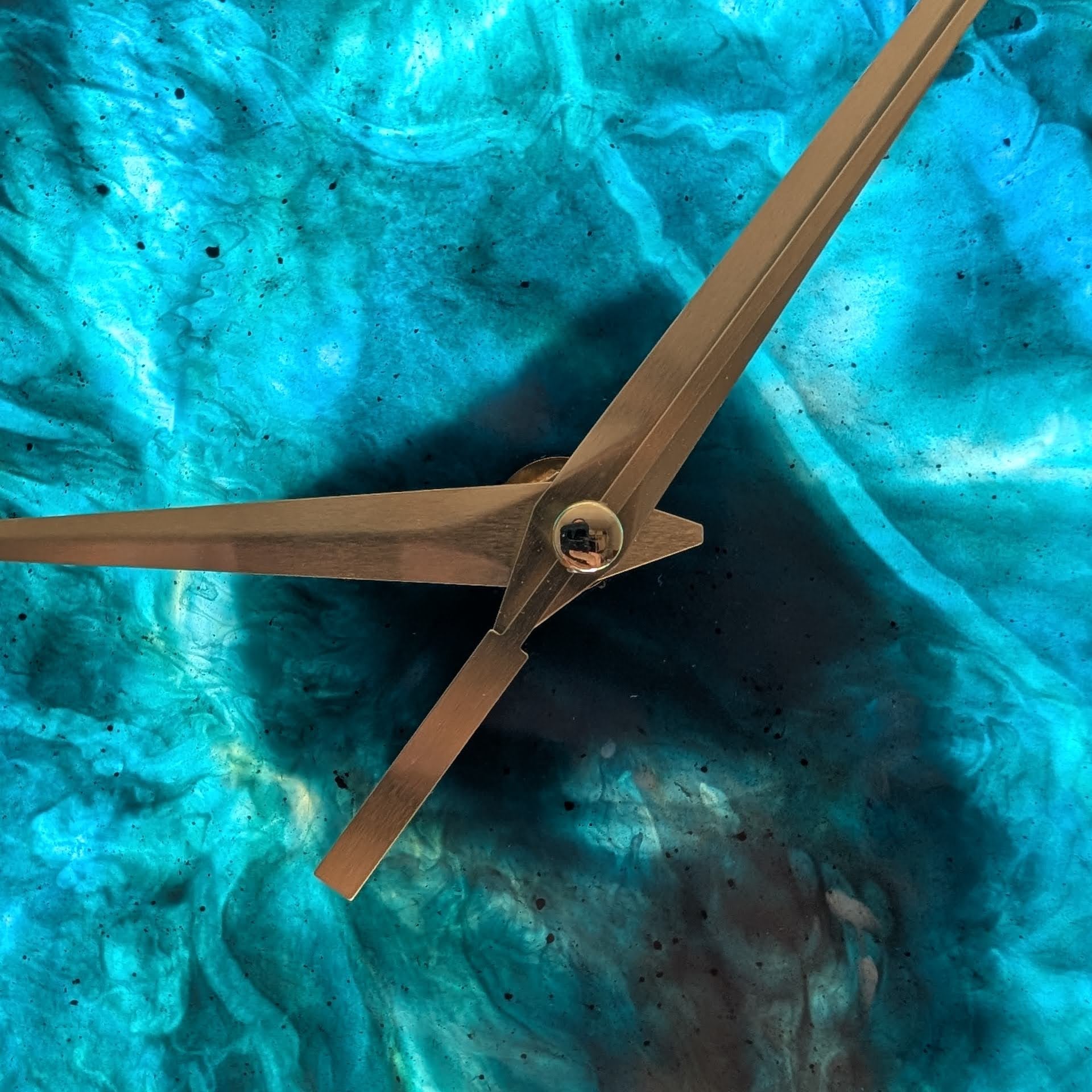 El detalle importa. Fina resina azul con vetas blancas que simulan el mar. Observa de cerca las elegantes agujas doradas de este reloj Skuld. Una pieza artesanal única.