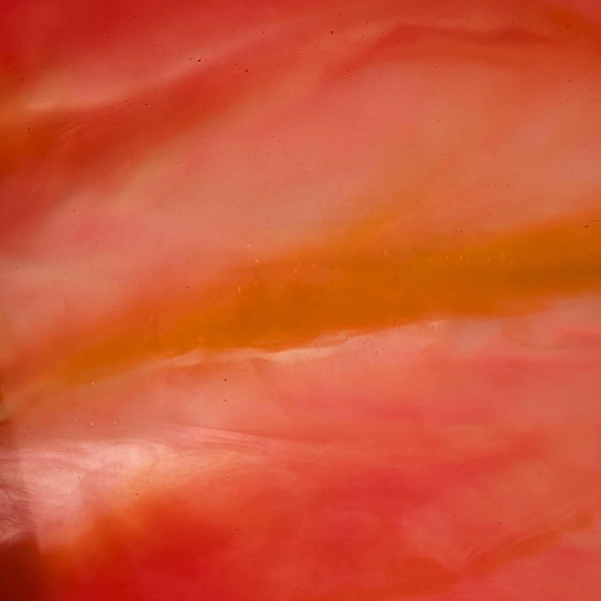 La resina artesanal del reloj Verdandi en primer plano. Descubre la vibrante fusión de frambuesa, naranja coral y las vetas nacaradas. Arte en detalle.