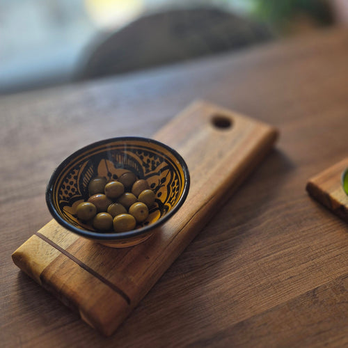 Tabla de servir Estrato, de acacia y bambú. Diseño estilizado con agujero funcional. Perfecta para aperitivos. Una pieza artesanal única para tu mesa.