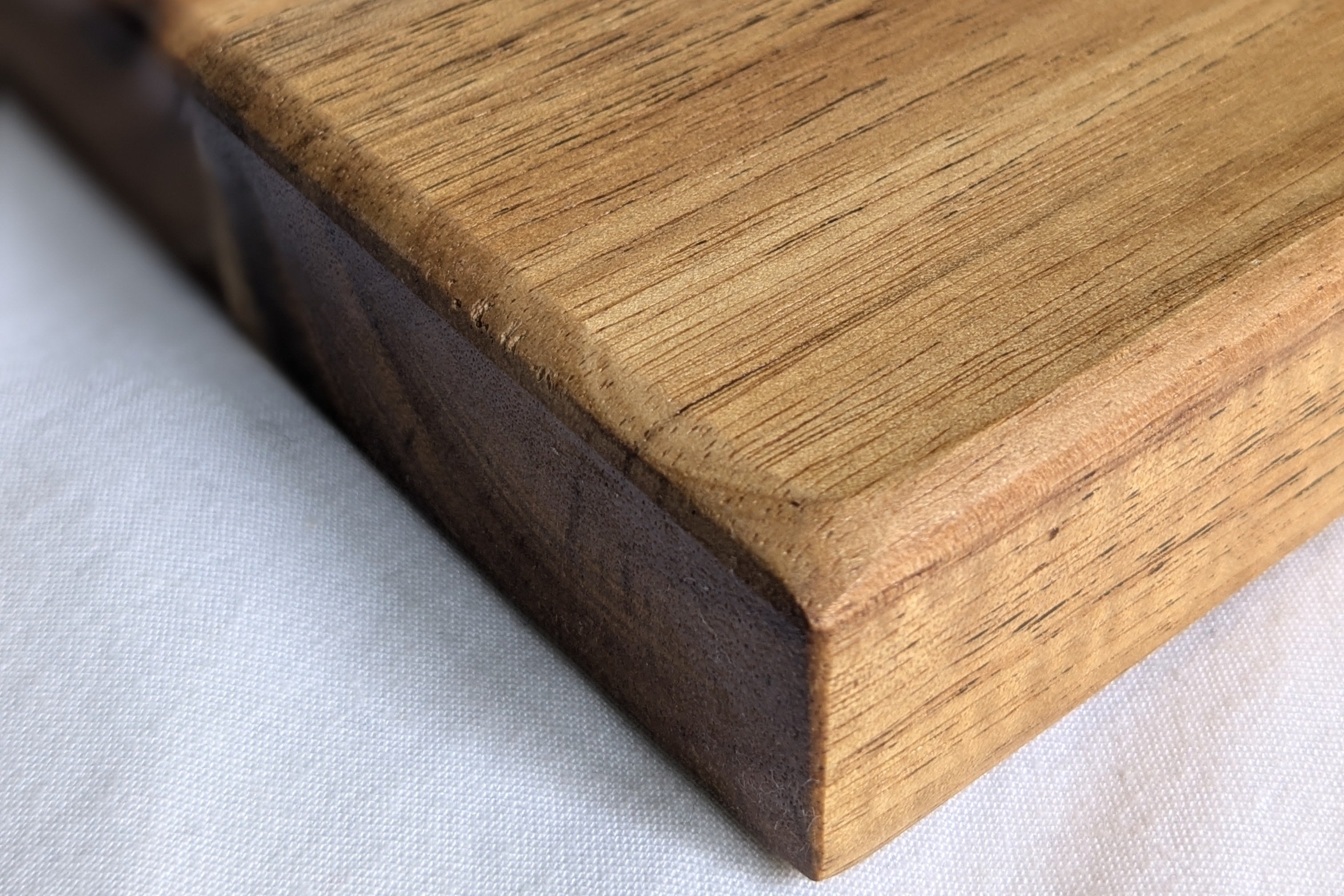 Detalle de la tabla Sierra. Acabados perfectos de la madera de acacia. La calidad y el trabajo hecho a mano en cada esquina de tu tabla.